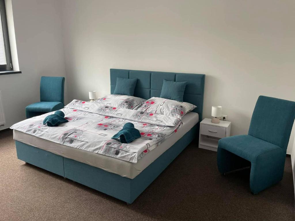 托普拉河畔弗拉诺夫RetroDym penzion的一间卧室配有一张床和两张蓝色椅子