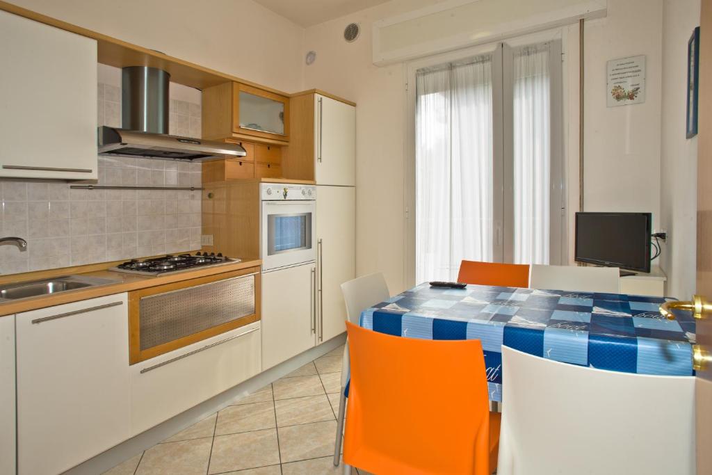 利多迪耶索罗Villa Hanna的厨房配有桌子和一些橙色椅子