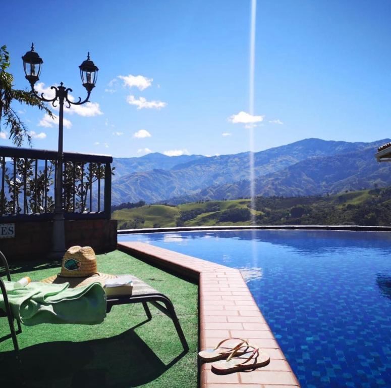 SalaminaCastillo de Cascadas Finca Hotel的坐在游泳池旁椅子上的人