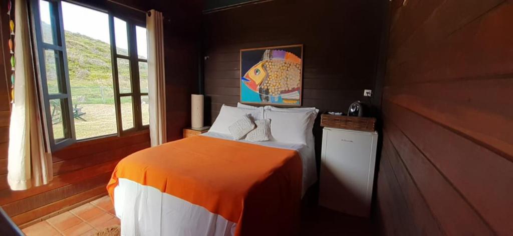 费尔南多 - 迪诺罗尼亚Apartamento Porto Beiramar的一间卧室配有一张带橙色和白色毯子的床