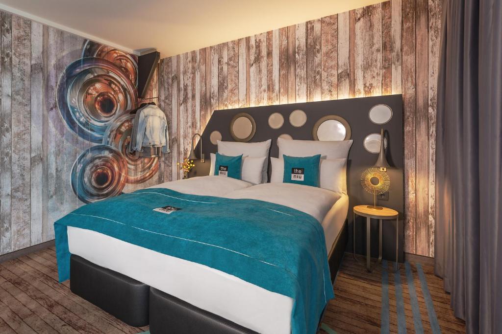 慕尼黑the niu Brass的一间卧室配有一张带蓝色毯子的大床