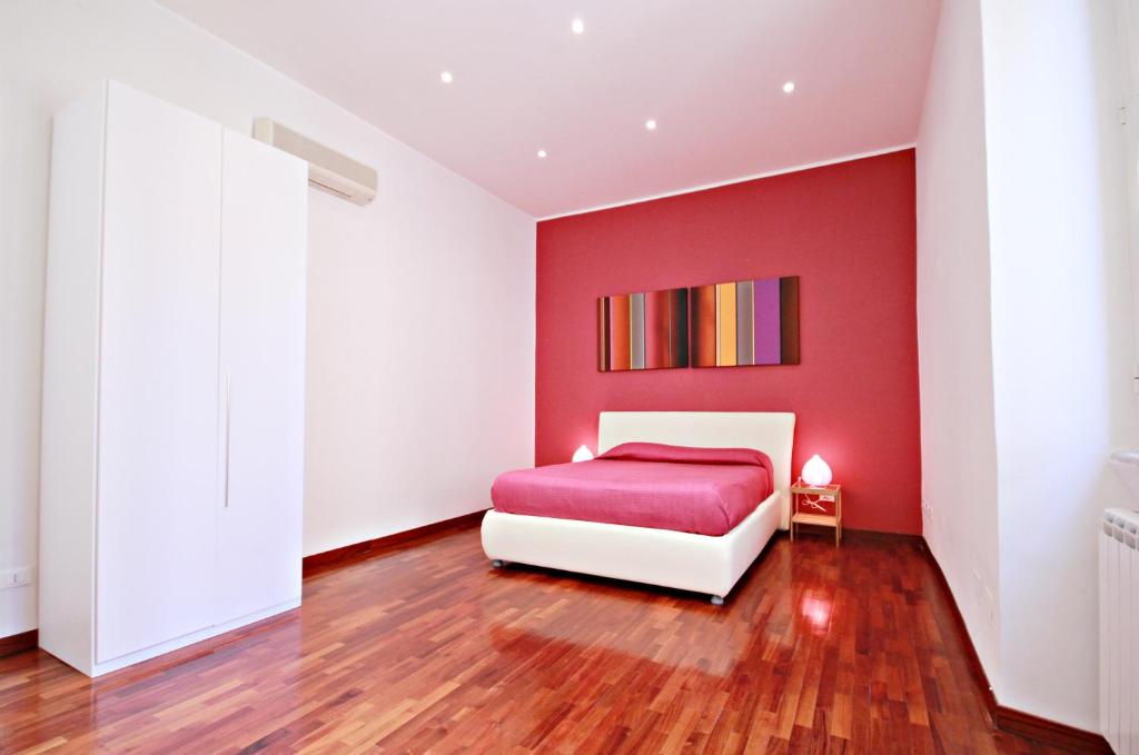罗马Rome Aparts的一间红色的卧室,配有白色的床和红色的墙壁