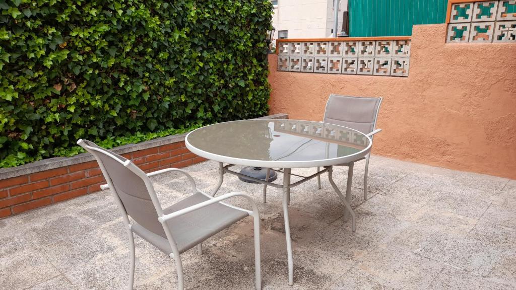 塞古德卡拉斐Apartamento con piscina y bonita terraza的天井上配有两把椅子和一张玻璃桌