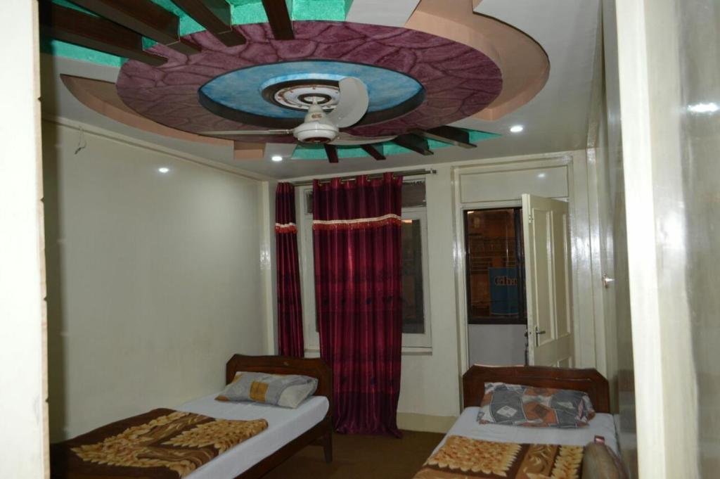 KachāhriHotel Deluxe的一间卧室设有两张床和天花板