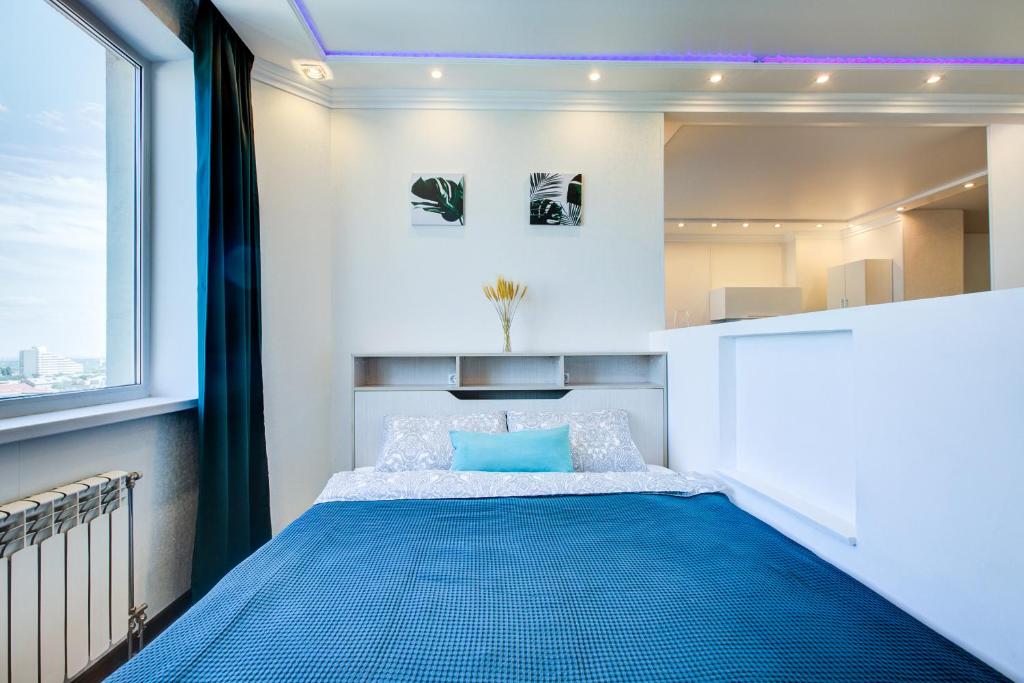沃罗涅什Royal Park Заселение Дистанционно的一间卧室设有蓝色的床和窗户。