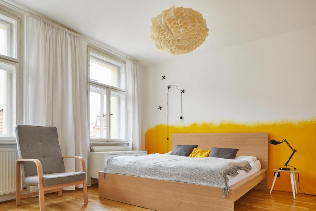 布拉格Cozy Flat in New Town by Prague Days的一间卧室配有一张床、一把椅子和一个吊灯。
