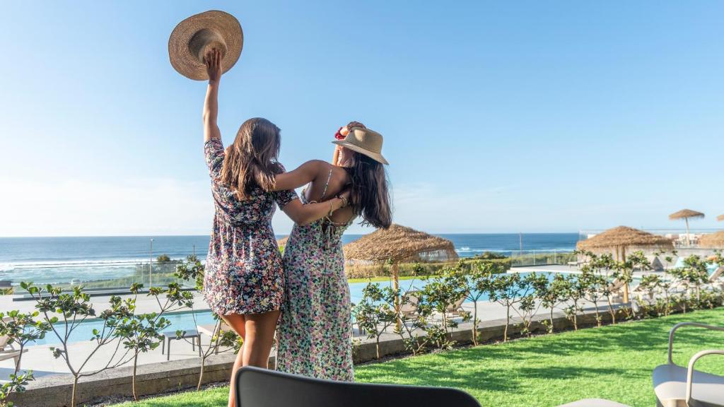 大里贝拉Hotel Verde Mar & SPA的两个女孩站在一个度假村的游泳池旁