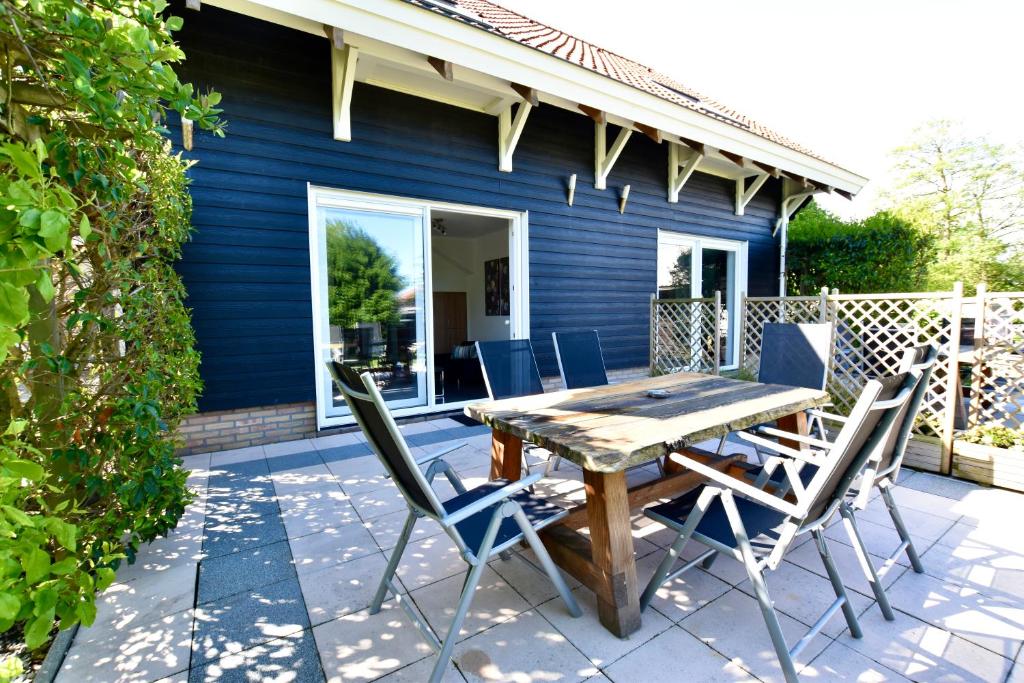 维斯可可Resort De Vlasschure的庭院配有木桌和椅子