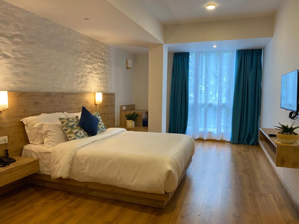 甘托克Manaslu的一间卧室设有一张大床和一个大窗户