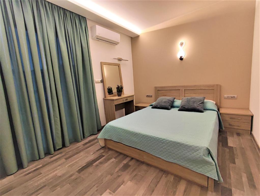 依克希亚Villa Pavlina的一间卧室配有大床和绿色窗帘