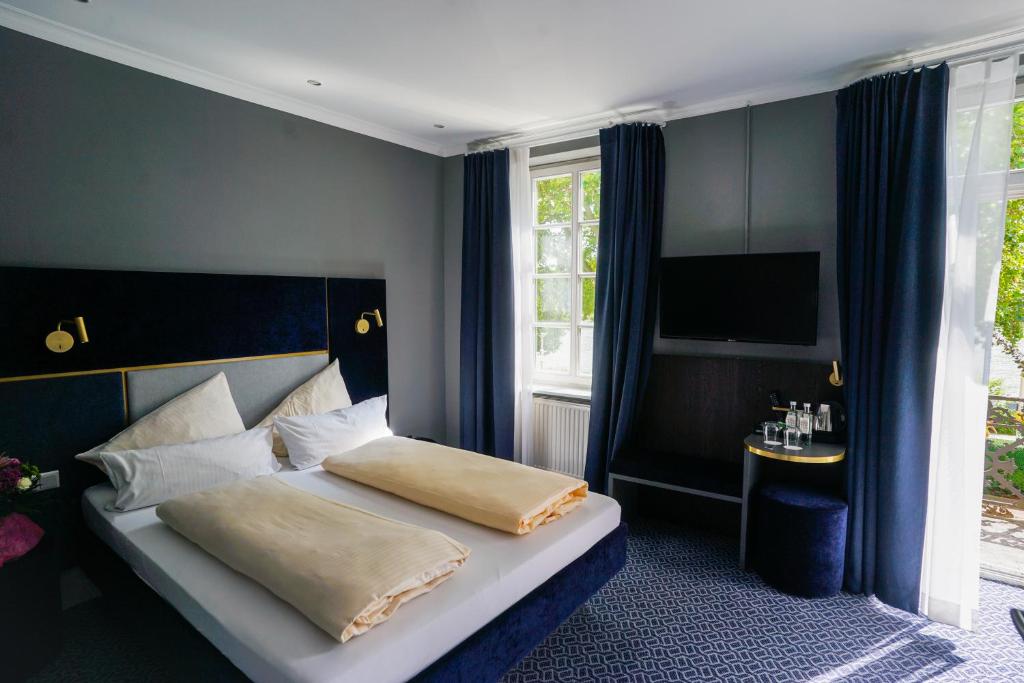 威斯巴登阿姆舒洛斯布里希酒店的一间卧室配有一张床和一台电视