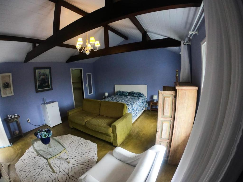 彼得罗波利斯Loft Aconchego da Serra的一间卧室配有一张床和一张沙发