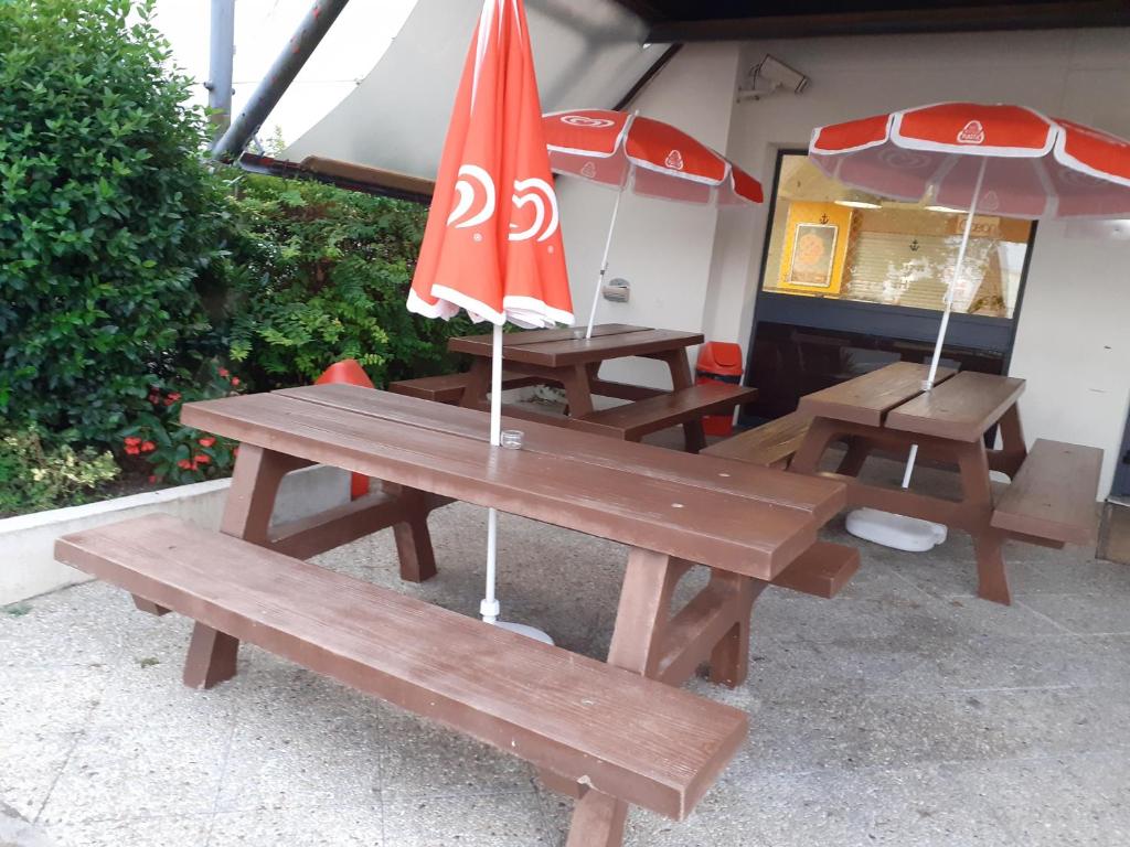 桑特桑特一级方程式酒店的两张带雨伞的野餐桌