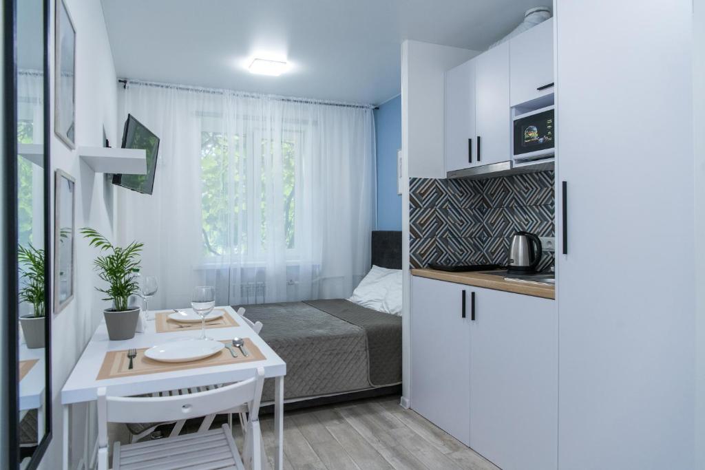 基辅MF Апартаменти пр-т Берестейський 106А的小房间设有床、桌子和厨房