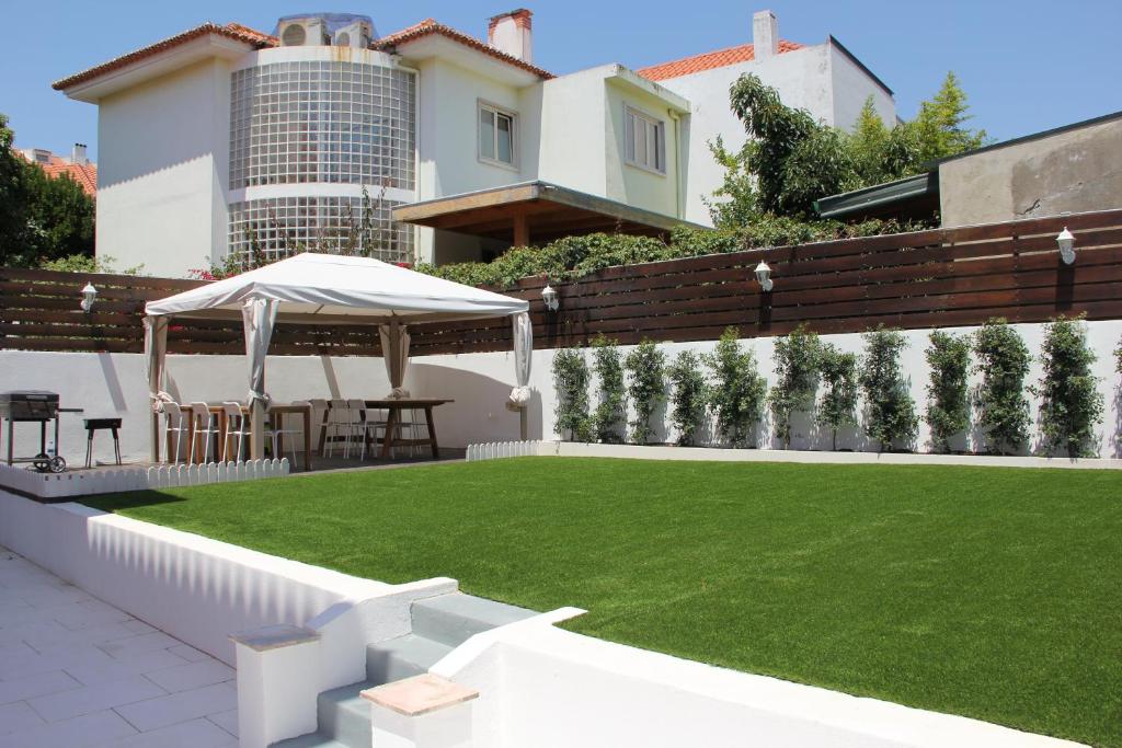 里斯本SK Lisboa Villa Guesthouse的后院设有草坪和凉亭