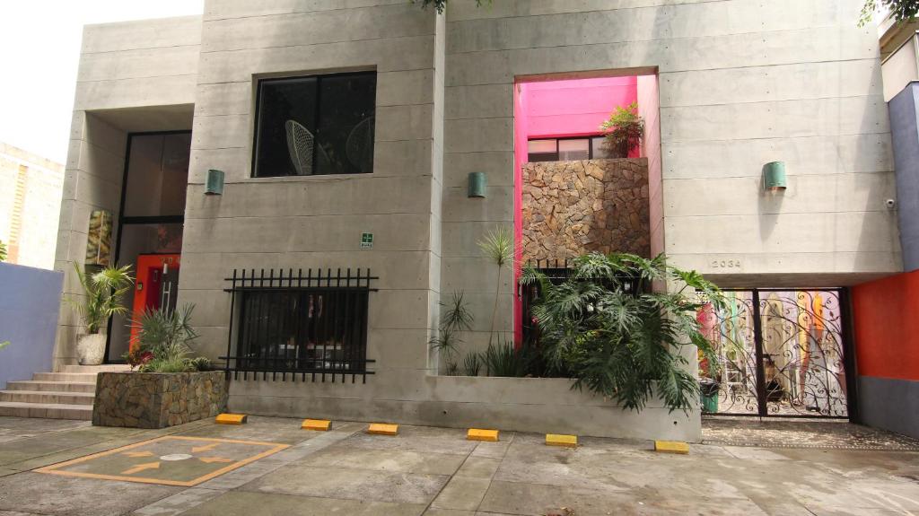瓜达拉哈拉Ekléctic Hotel Boutique的一座有粉红色门和一些植物的建筑