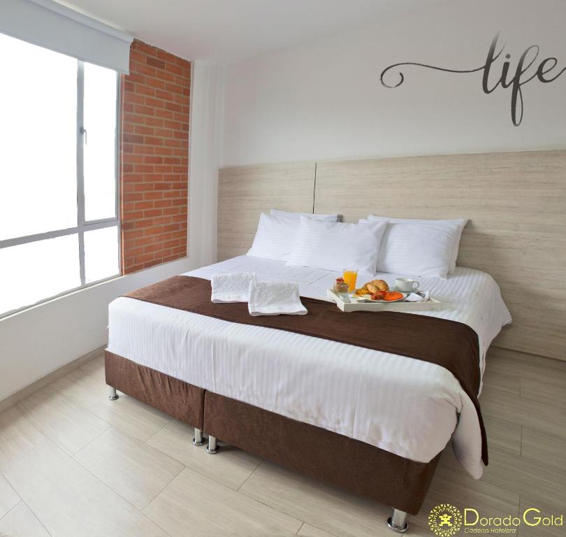 波哥大Hotel Bestmark Platino的一间卧室配有一张大床,上面有水果盘
