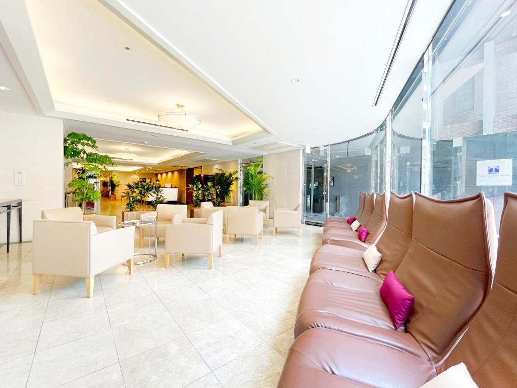 福冈Mars Garden Hotel Hakata的大堂设有真皮沙发和桌椅