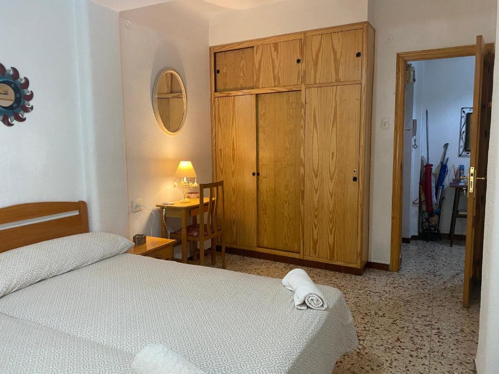 阿利坎特Guest House Capitan Meca的一间卧室配有一张床和一个木制橱柜
