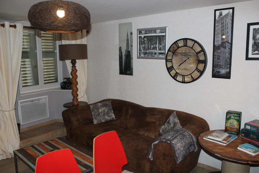 坦恩莱斯弗鲁斯蒂坦恩公寓的客厅配有沙发和墙上的时钟
