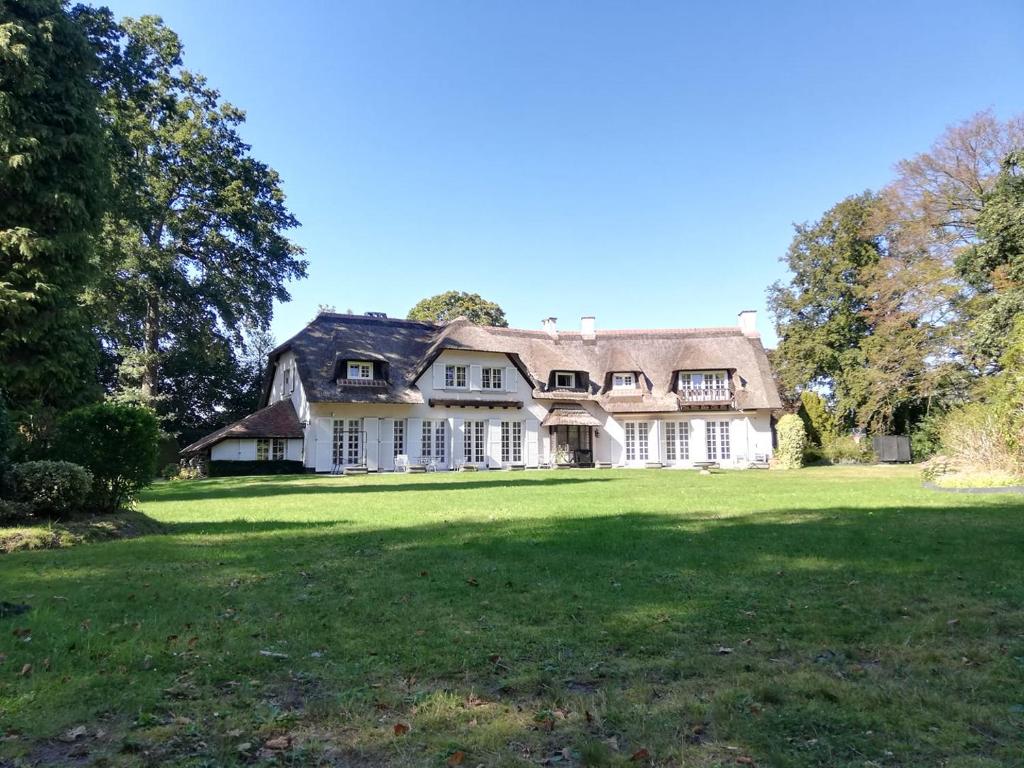 欧迪尼斯Villa Monceau的一座大型白色房子,设有大片草地