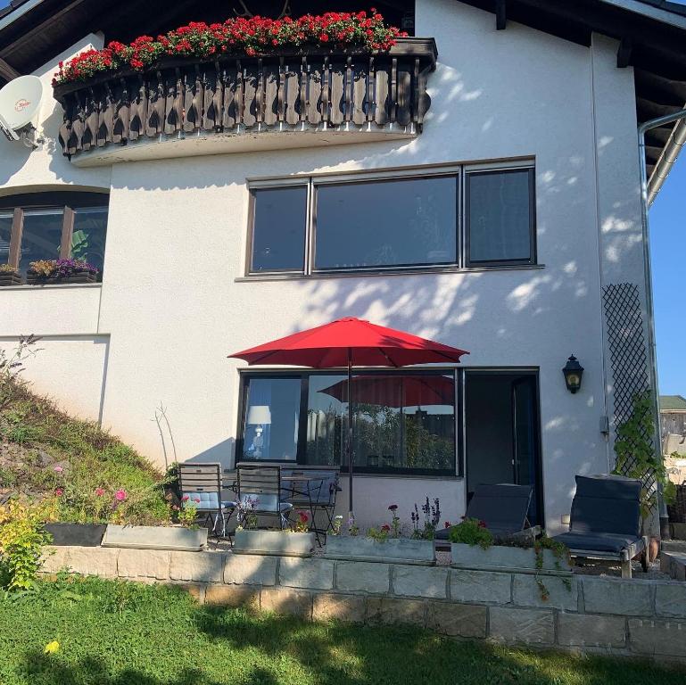 于林根-比肯多夫Ferienwohnung Klosterblick的坐在房子前面的红伞