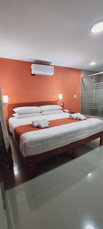 圣胡安Ensenada Hotel的一张位于橙色墙壁的大床