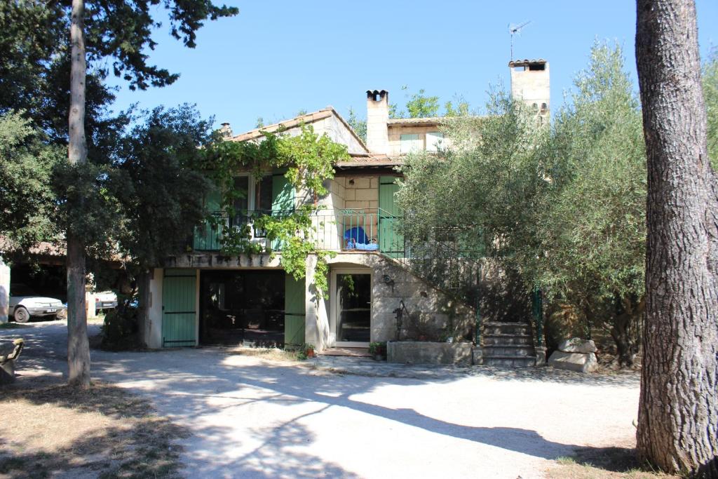 博凯尔Le mas de Lucien entre Arles, Nimes, Avignon.的前面有一棵树的老房子