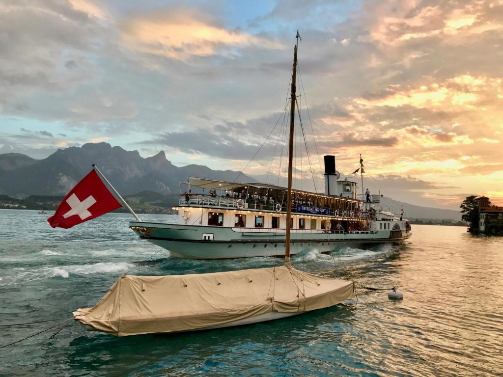 图恩湖畔上霍芬Chalet Oberhofen am Thunersee的船在水中悬挂瑞士国旗