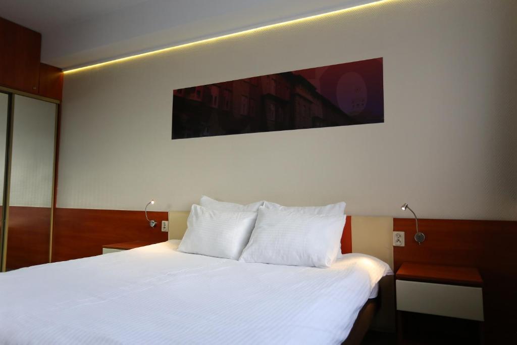 卡托维兹euroHOTEL Katowice Nikiszowiec的一间卧室配有一张带白色床单的大床