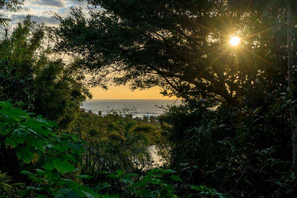 普腊亚罗萨Coração da Terra Praia do Rosa的阳光明媚的海滩上可欣赏到海景