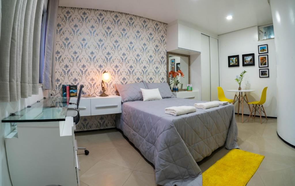 维索萨-杜塞阿拉Flat da Vila的一间卧室配有一张床和一张玻璃桌