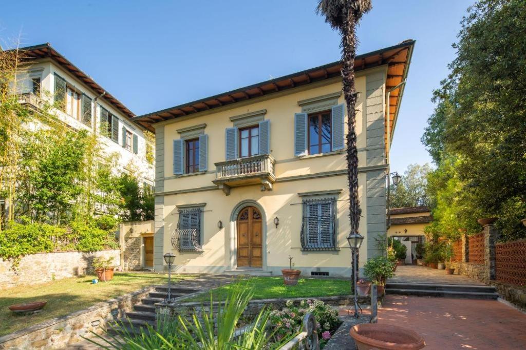 佛罗伦萨Villa Lia - Apartment in Villa with private garden and Pool的前面有棕榈树的房子
