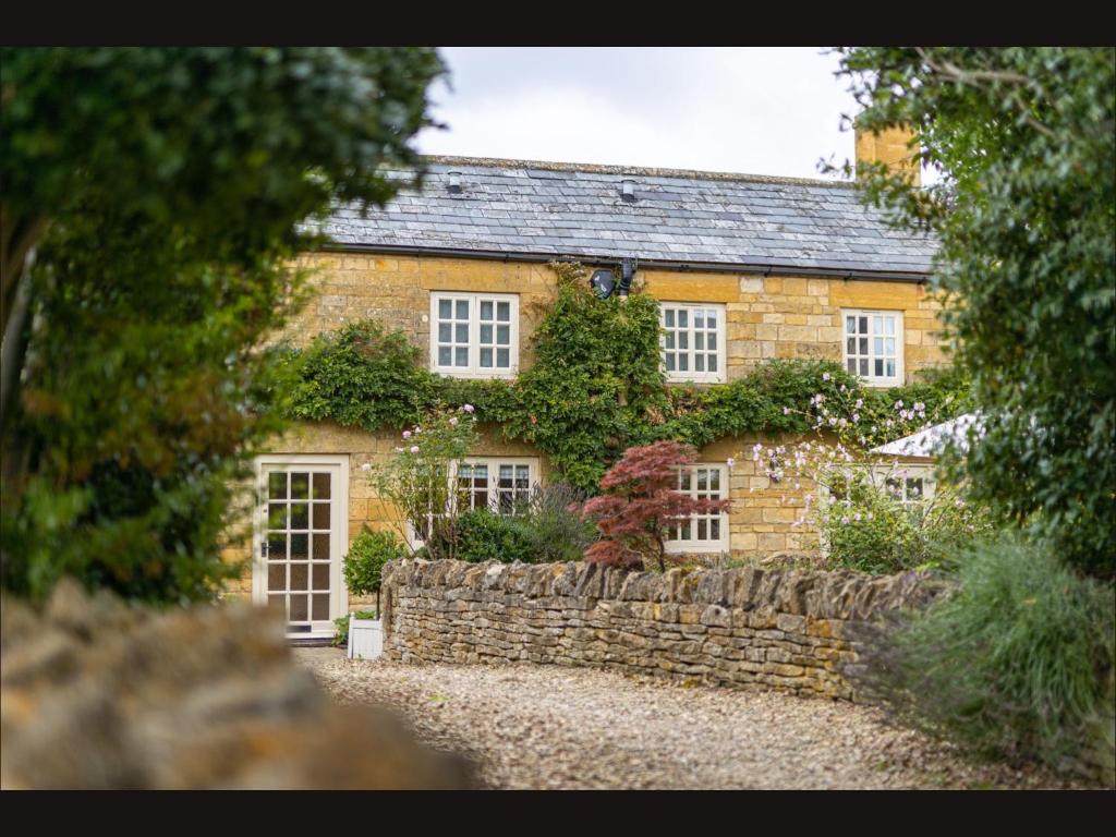 Weston SubedgeWisteria Cottage , Pretty Cotswold Cottage close to Chipping Campden的一座石墙的旧砖房子