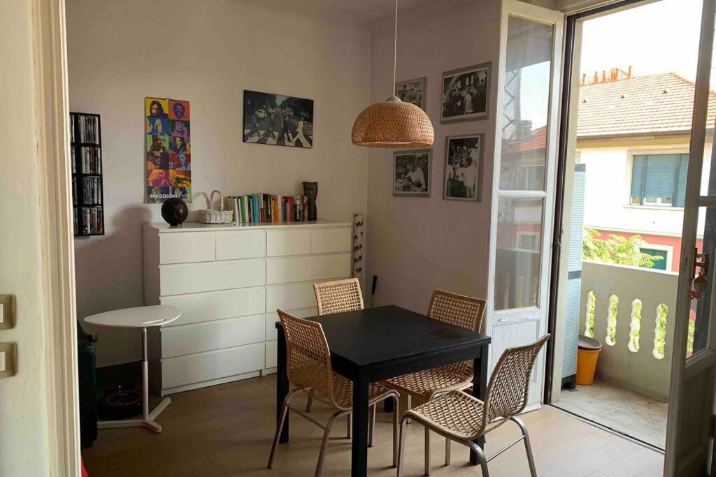 米兰Appartamento splendido con tutti servizi in zona Navigli的一间用餐室,配有黑色的桌子和椅子