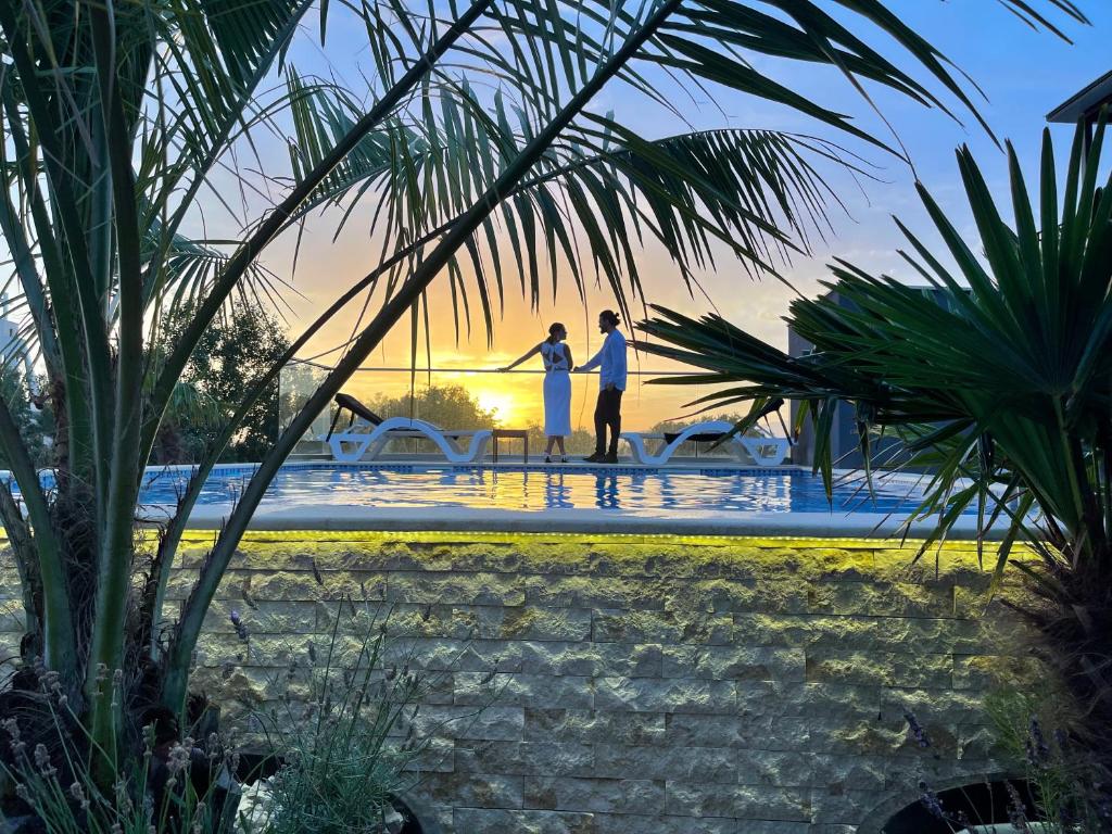 乌尔齐尼AM Palace的两人在日落时站在游泳池边