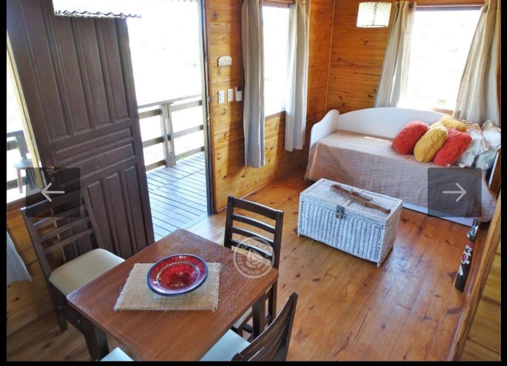 德尔迪阿布罗角法玛山林小屋的客房设有一张床、一张桌子和一张桌子以及椅子。