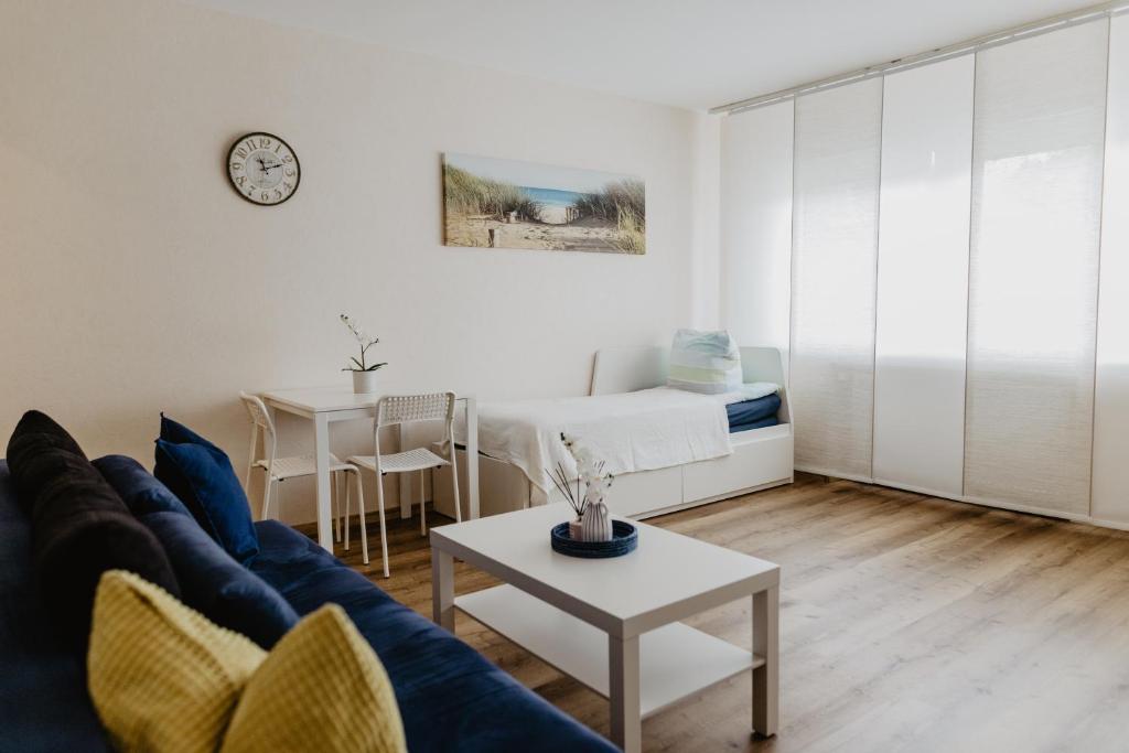 盖尔森基兴SK Apartments - Sandwood的客厅配有蓝色的沙发和桌子