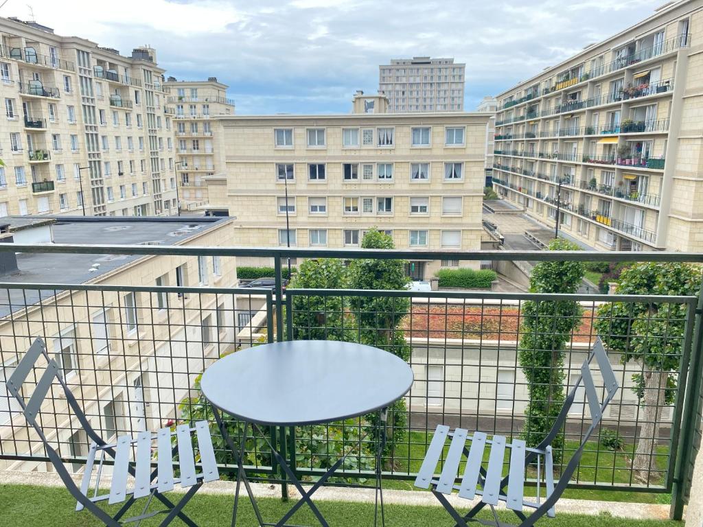 勒阿弗尔Vivez Le Centre ville à la Plage - Balcon的阳台配有桌子和两把椅子,阳台设有建筑