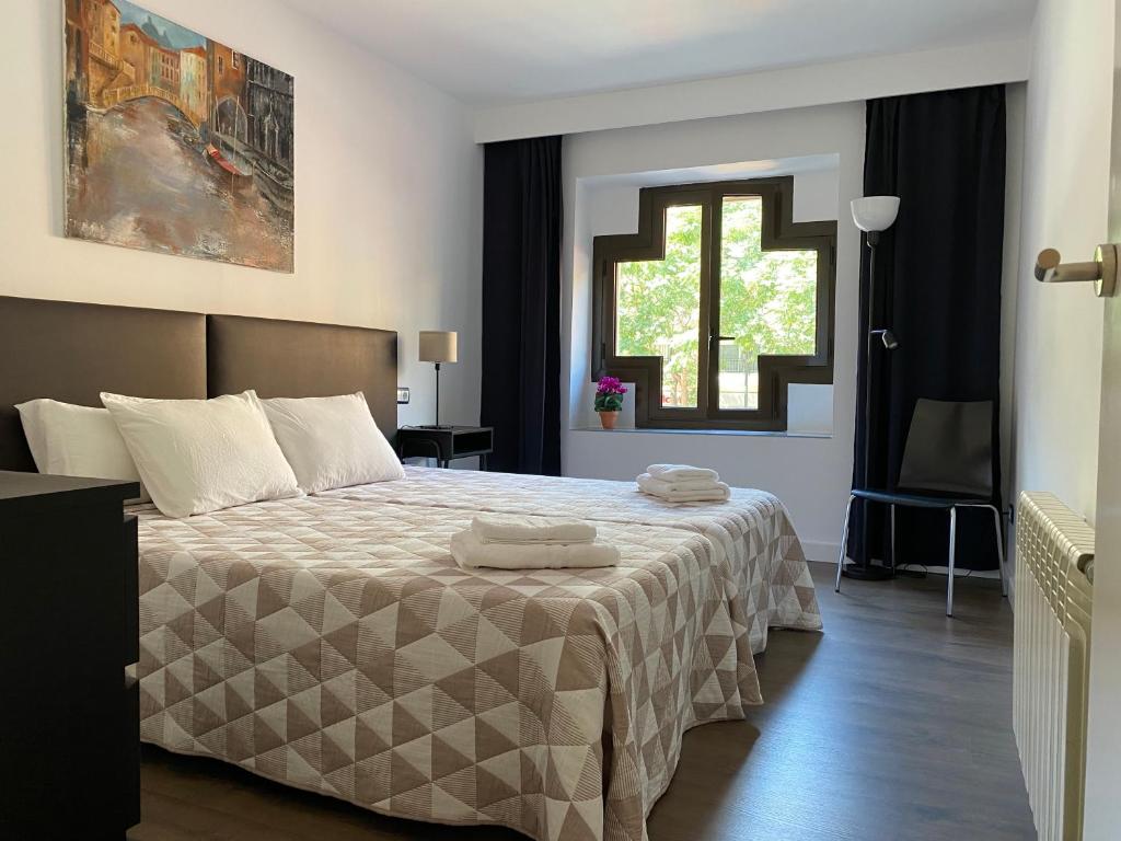 萨拉戈萨LC Apartamentos César Augusto的一间卧室配有一张床,上面有两条毛巾