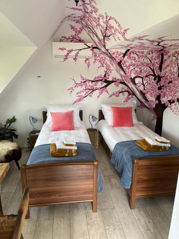 德拉赫滕B&B Bijzonder的配有樱桃树壁画的客房内的两张床