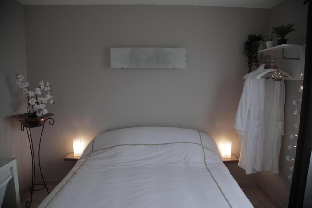 Lucbardez-et-BarguesAu Doux Repos的一间卧室配有一张带两个灯的床