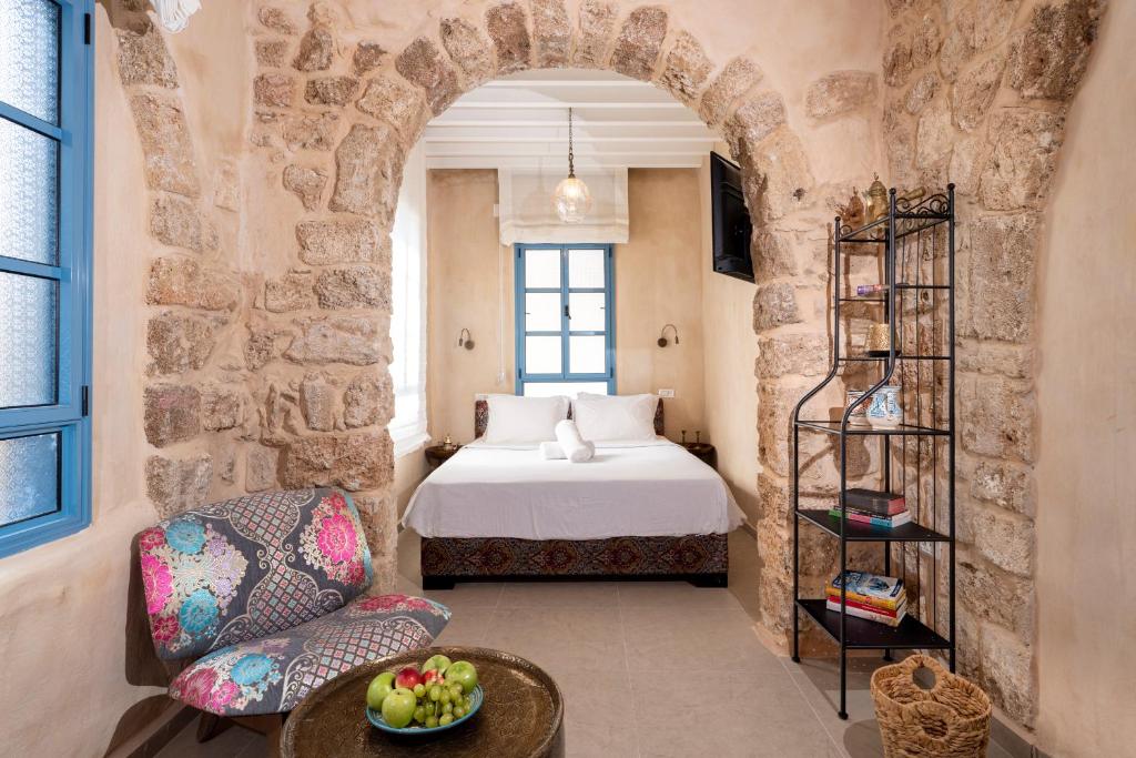 阿卡Arabesque House的一间卧室配有一张床、一把椅子和一张桌子