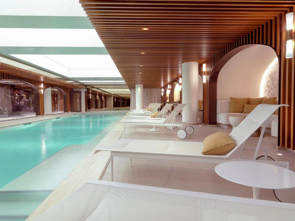 巴黎多布松酒店的酒店游泳池设有躺椅和游泳池