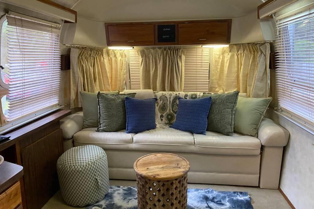 博福特Beautiful Airstream, Beaufort SC-Enjoy the Journey的客厅配有带蓝色枕头的沙发