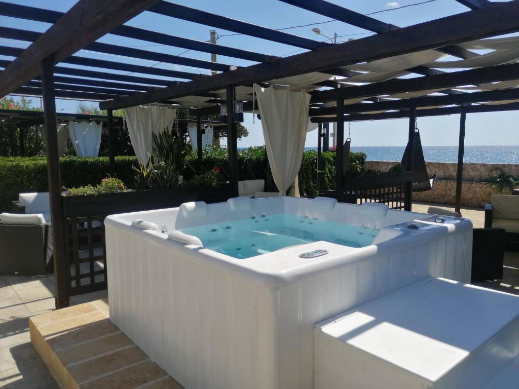 托雷圣乔万尼乌La Giara Resort的凉棚下天井上的热水浴池