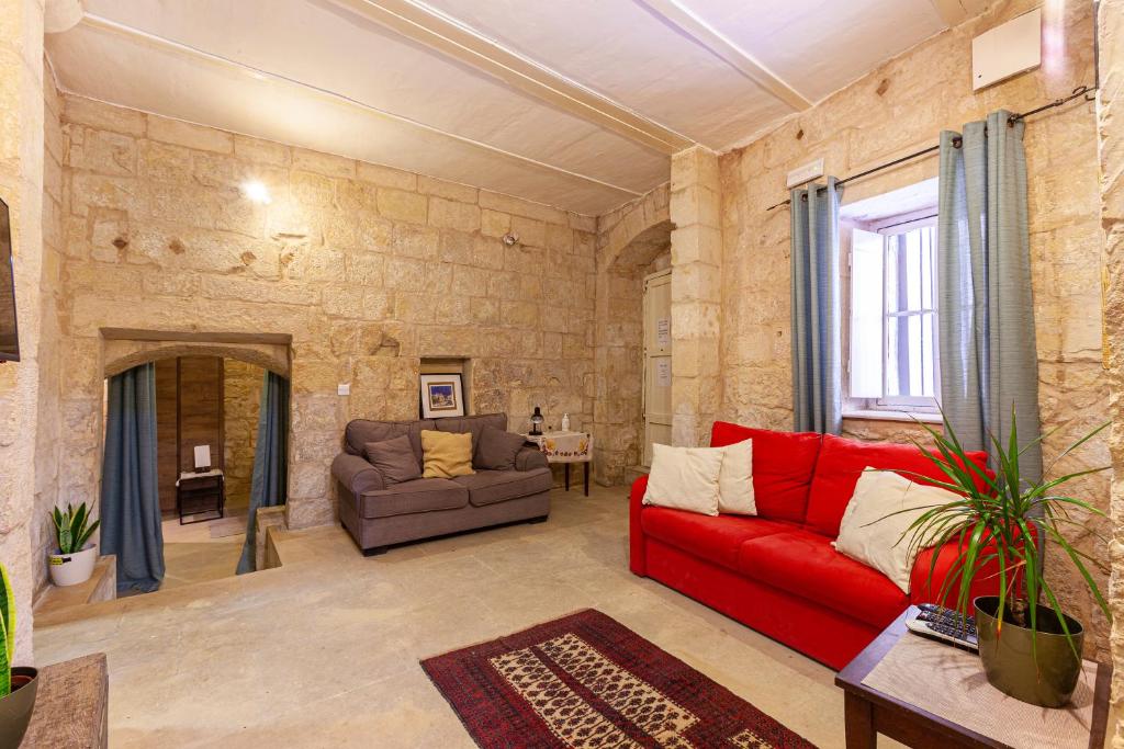 维洛里奥萨BRG34 - Historical Vittoriosa Townhouse的客厅配有红色的沙发和椅子