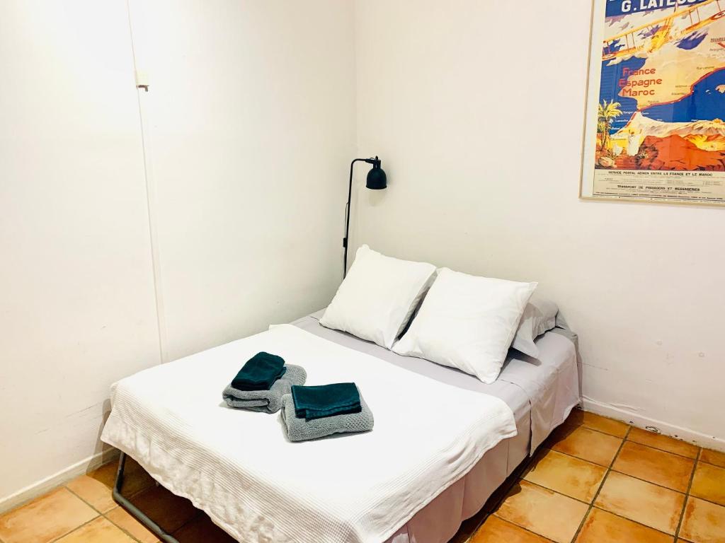 图卢兹Studio des Carmes的一间卧室配有一张床,上面有两条毛巾