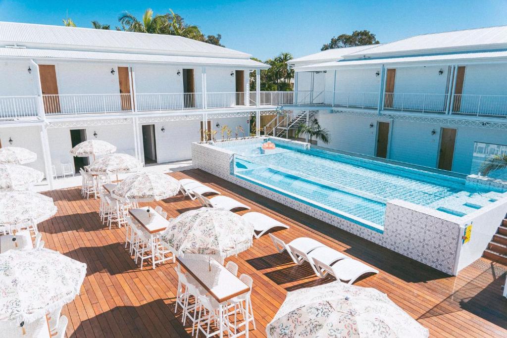 努萨维尔Bounce Noosa的一个带游泳池和桌椅的度假酒店