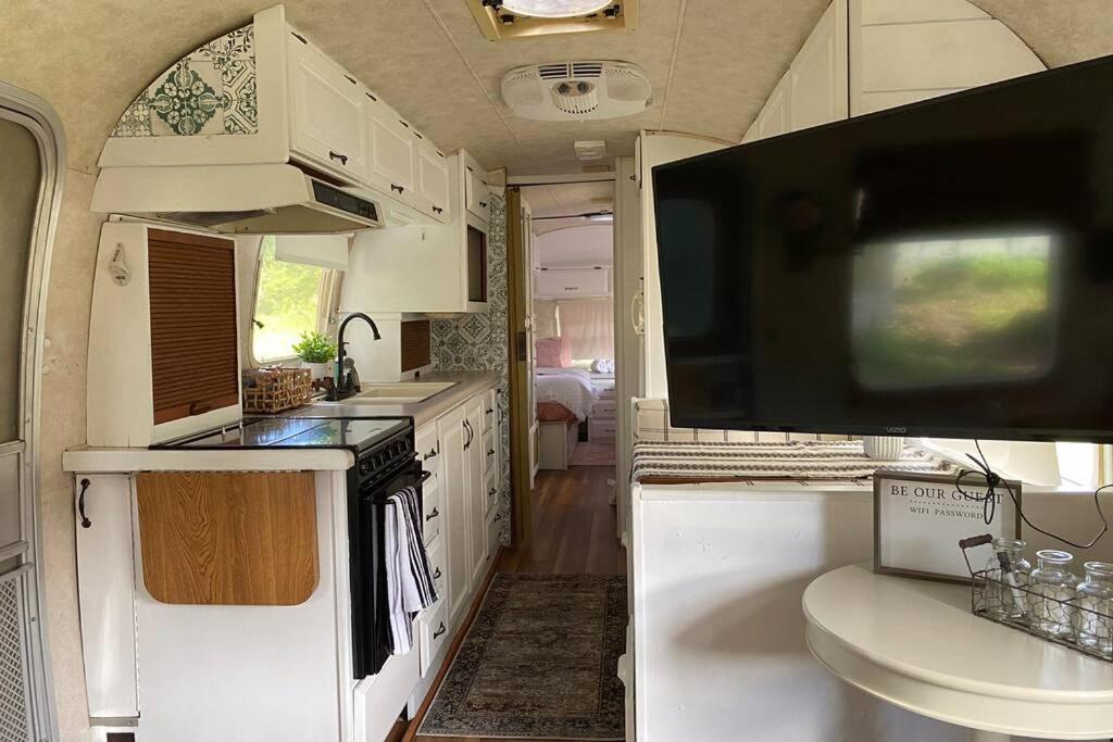 博福特Amazing Airstream, Beaufort, SC-Enjoy the Journey的一个大篷车内的厨房,配有大电视